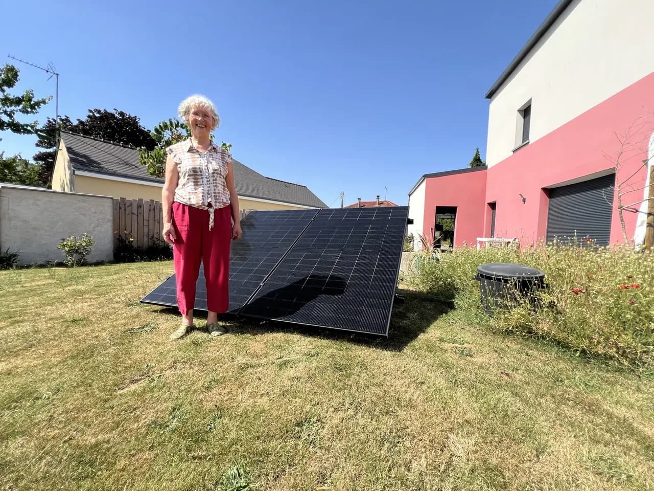 Cliente Solaren devant son kit solaire plug and play posé dans son jardin